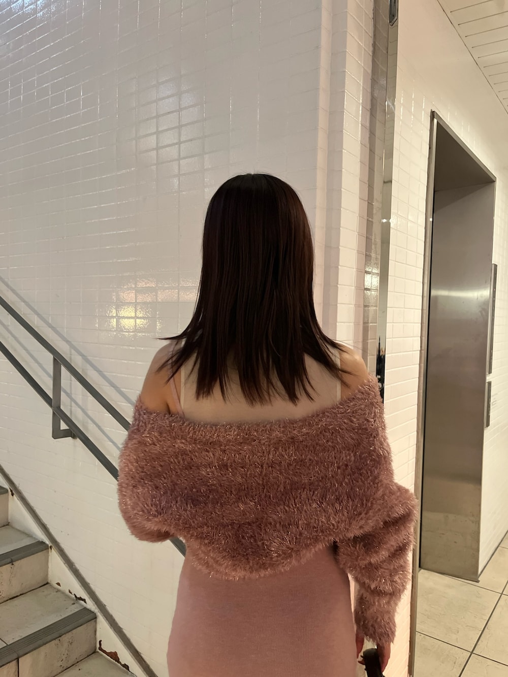 ピンク系のワンピース、ブラウン系のハンドバッグを着用したレディースの冬コーディネートの6枚目の写真