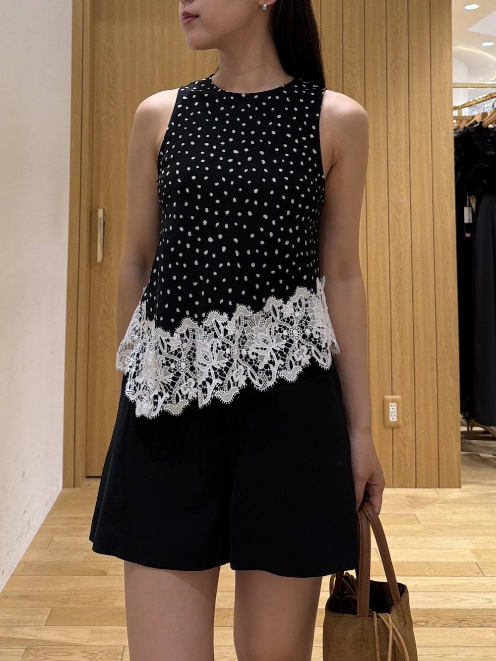 ブラック系のその他パンツ、イエロー系のハンドバッグ、ブラック系のブーツを着用したレディースの夏コーディネートの4枚目の写真