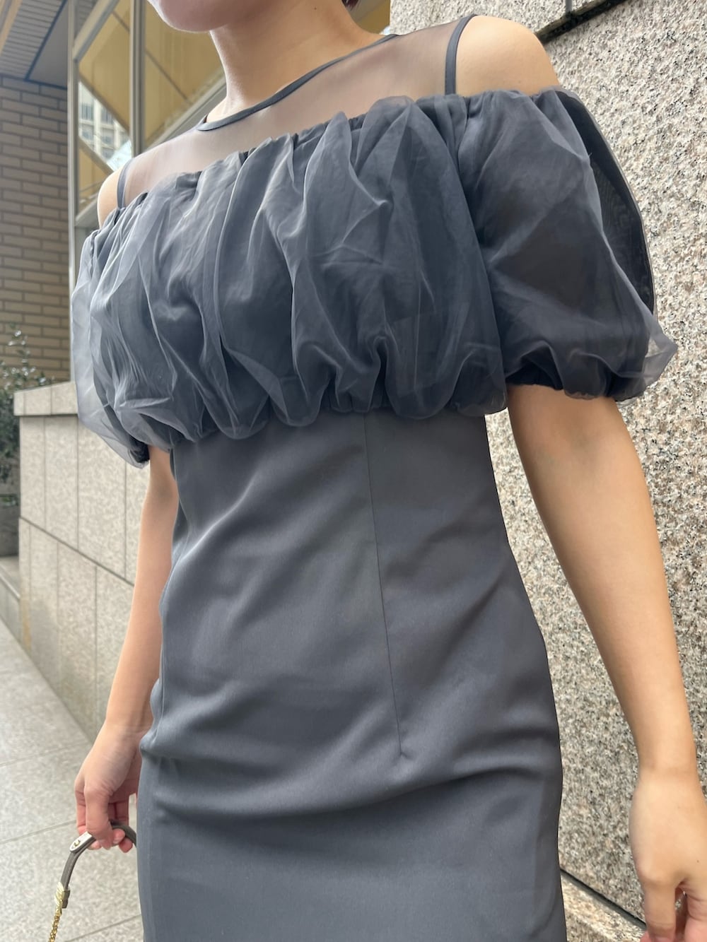 グレー系のドレス、シルバー系のパンプス、シルバー系のハンドバッグを着用したレディースの冬コーディネートの8枚目の写真