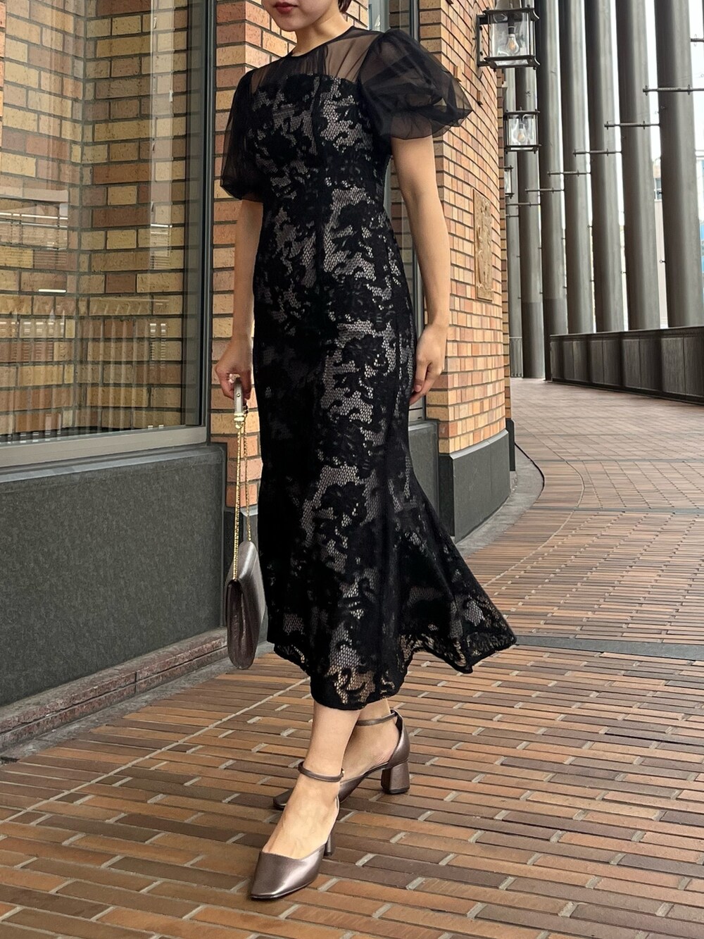 ブラック系のドレス、その他のパンプス、シルバー系のハンドバッグを着用したレディースの冬コーディネートの4枚目の写真