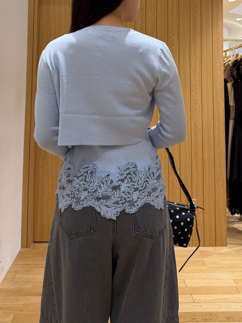 グレー系のデニムパンツ、ブルー系のニット/セーター、ブラック系のブーツを着用したレディースの秋コーディネートの6枚目の写真