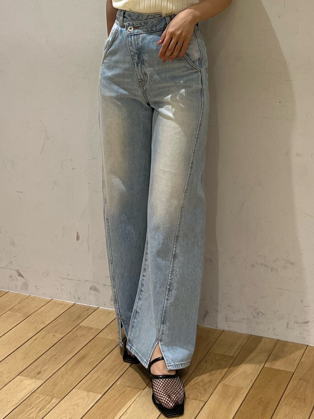 ブルー系のデニムパンツ、ブラック系のサンダル、ホワイト系のTシャツ/カットソーを着用したレディースの春コーディネートの7枚目の写真