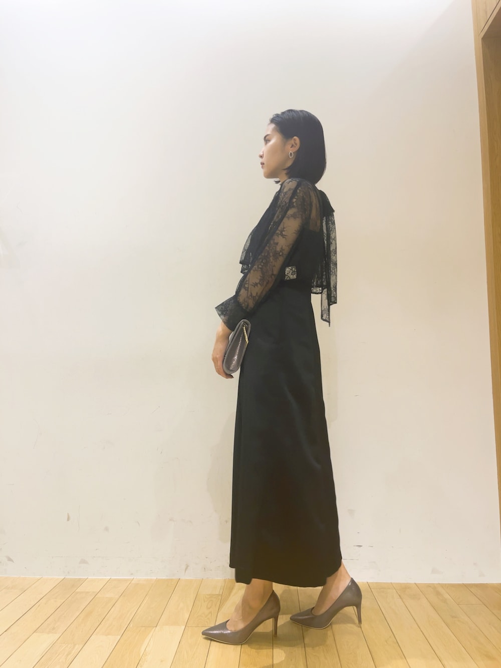 ブラック系のドレス、シルバー系のハンドバッグ、シルバー系のパンプスを着用したレディースの夏コーディネートの4枚目の写真