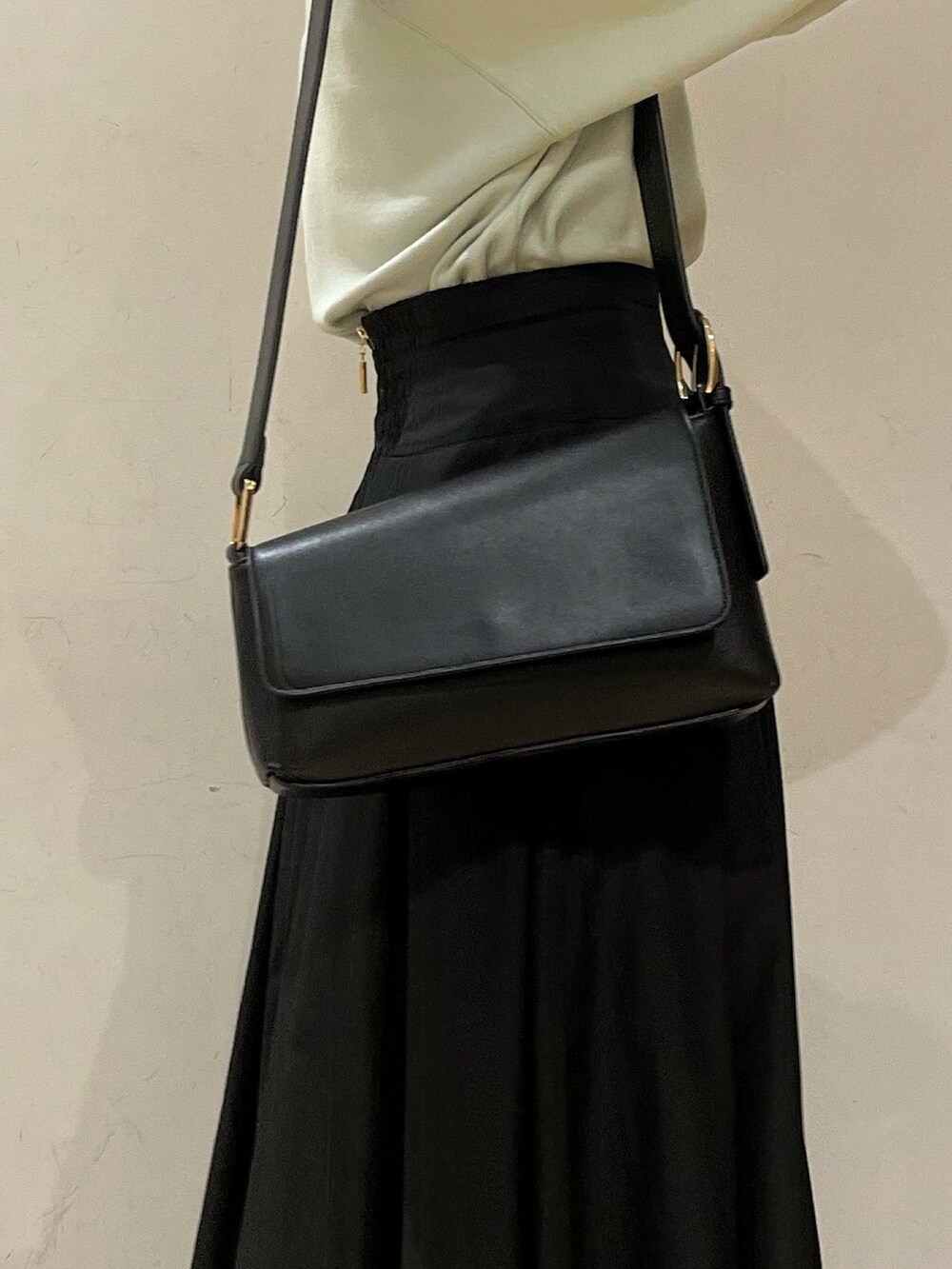 ブラック系のブーツ、ブラック系のスカート、グリーン系のニット/セーターを着用したレディースの冬コーディネートの4枚目の写真