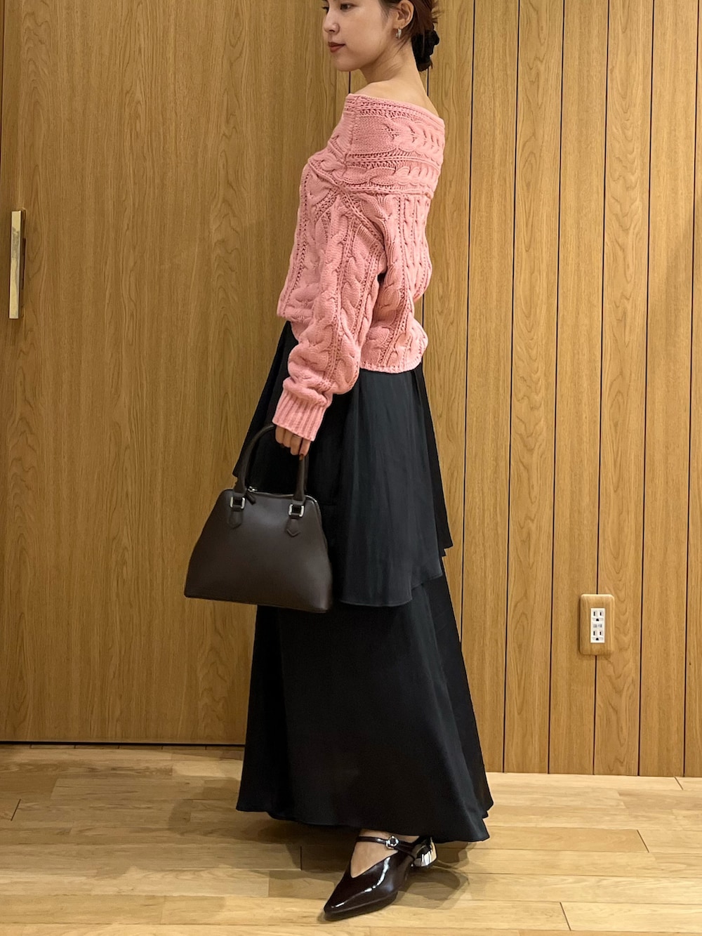ブラウン系のパンプス、ブラック系のスカート、ピンク系のニット/セーターを着用したレディースの秋コーディネートの2枚目の写真