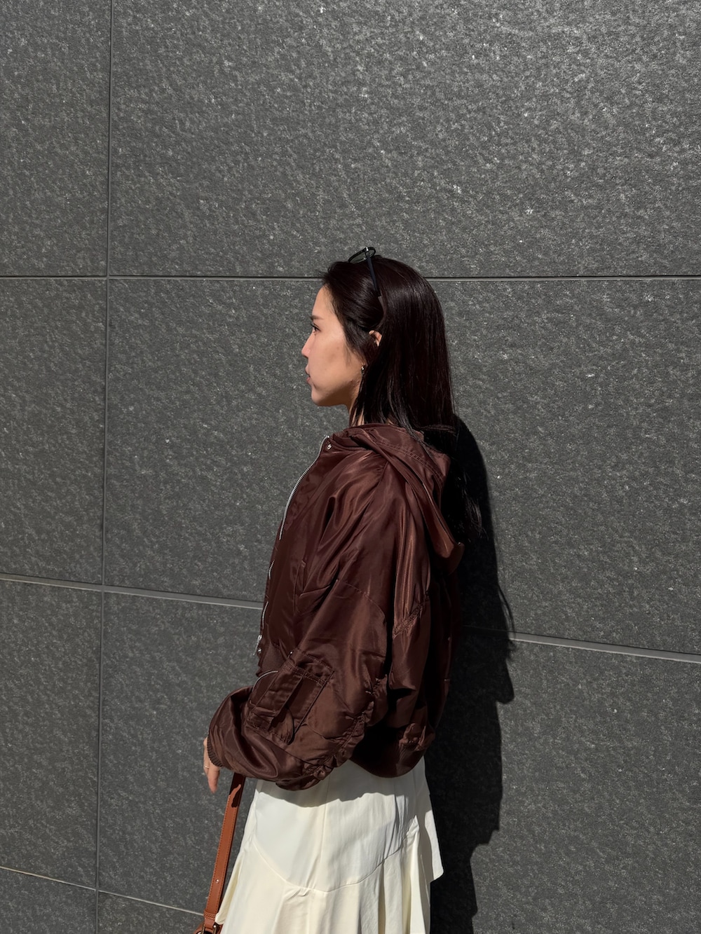 ブラック系のニット/セーター、ホワイト系のスカート、ブラウン系のブルゾンを着用したレディースの冬コーディネートの6枚目の写真