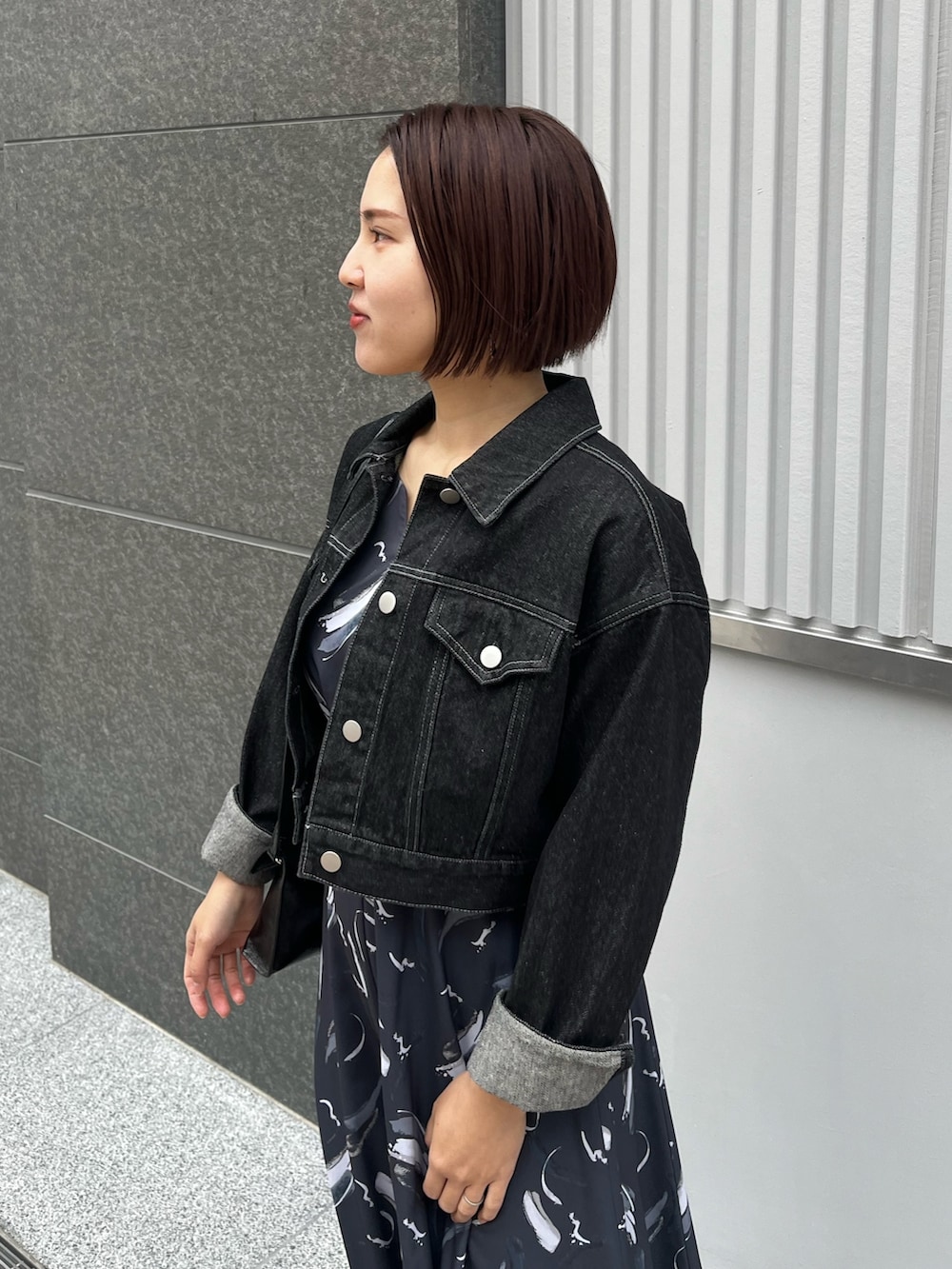 ブラック系のハンドバッグ、ブルー系のワンピース、シルバー系のパンプスを着用したレディースの春コーディネートの4枚目の写真