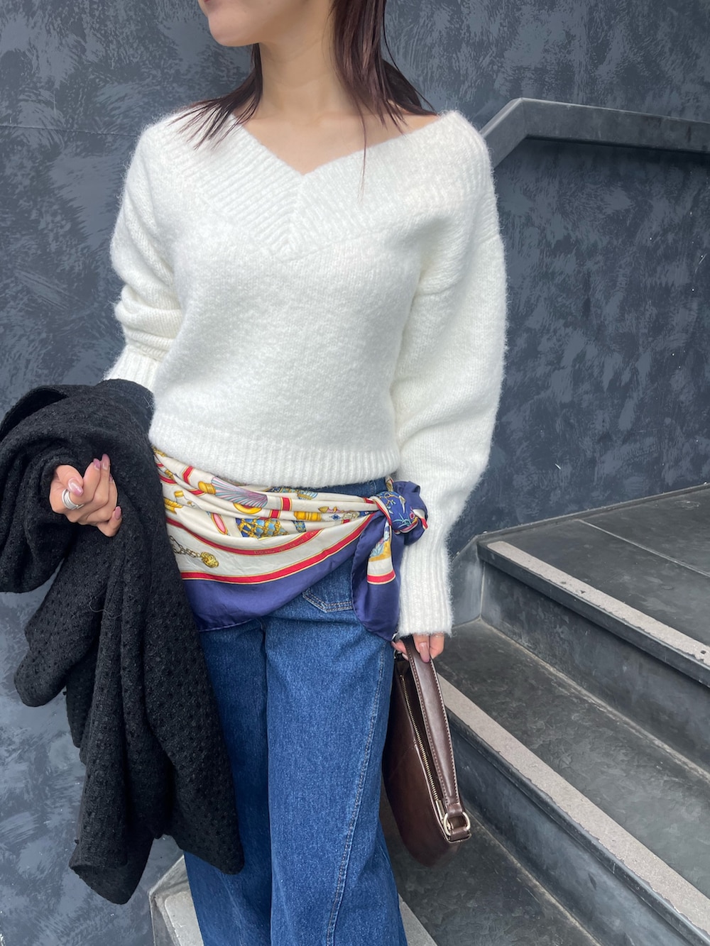 ホワイト系のニット/セーター、ブルー系のデニムパンツ、ブラウン系のハンドバッグを着用したレディースの冬コーディネートの4枚目の写真