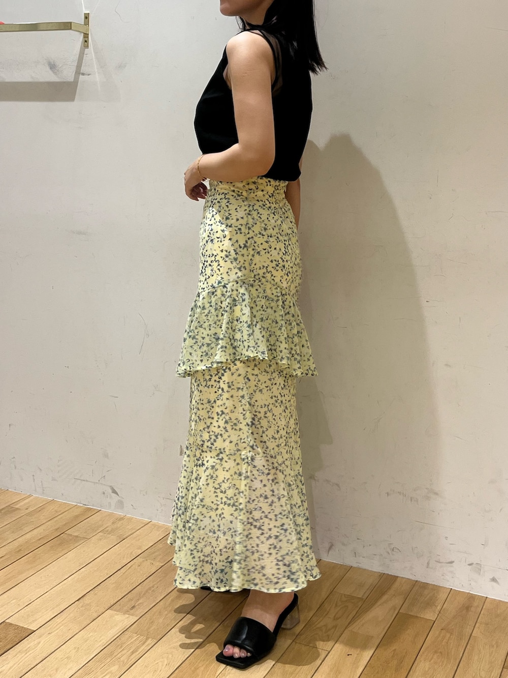 グリーン系のスカート、ブラック系のTシャツ/カットソーを着用したレディースの夏コーディネートの2枚目の写真