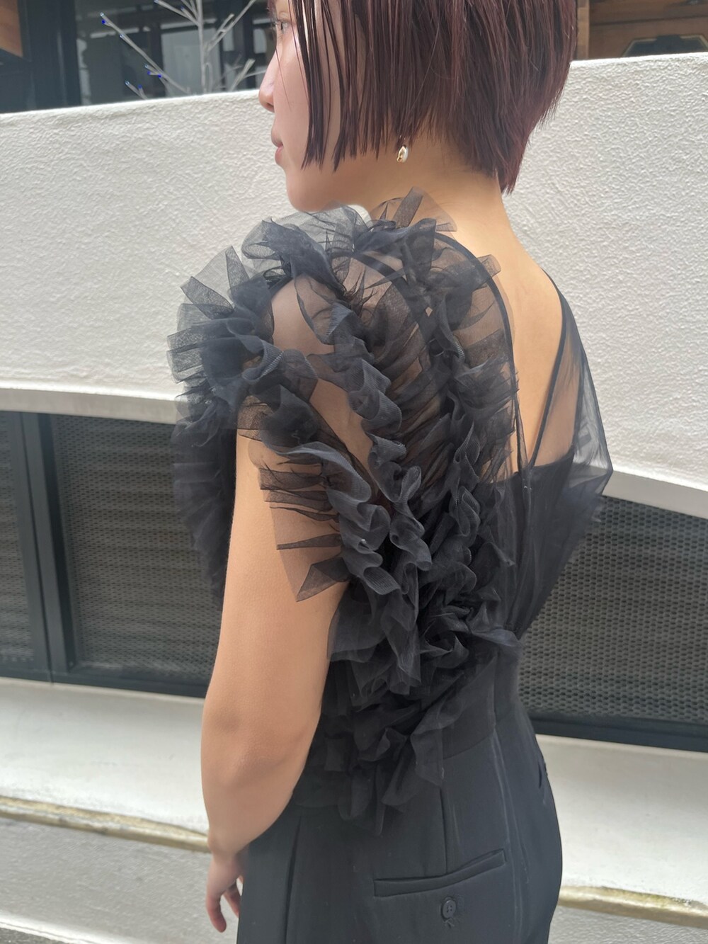 ブラック系のパンツドレス、その他のパンプス、シルバー系のハンドバッグを着用したレディースの冬コーディネートの6枚目の写真