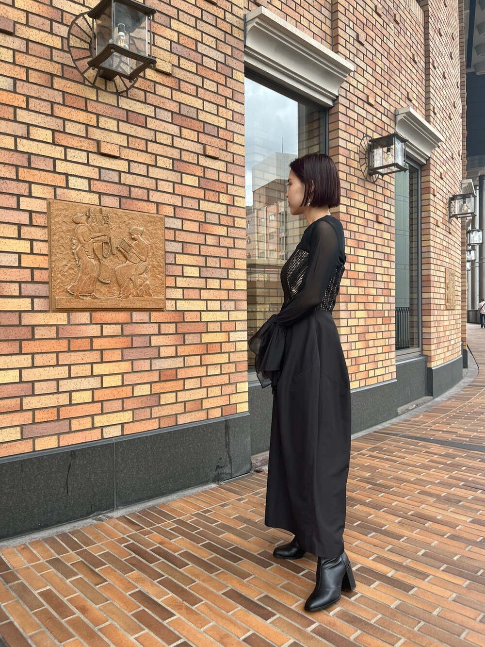 ブラック系のTシャツ/カットソー、ブラック系のドレス、シルバー系のハンドバッグを着用したレディースの秋コーディネートの4枚目の写真