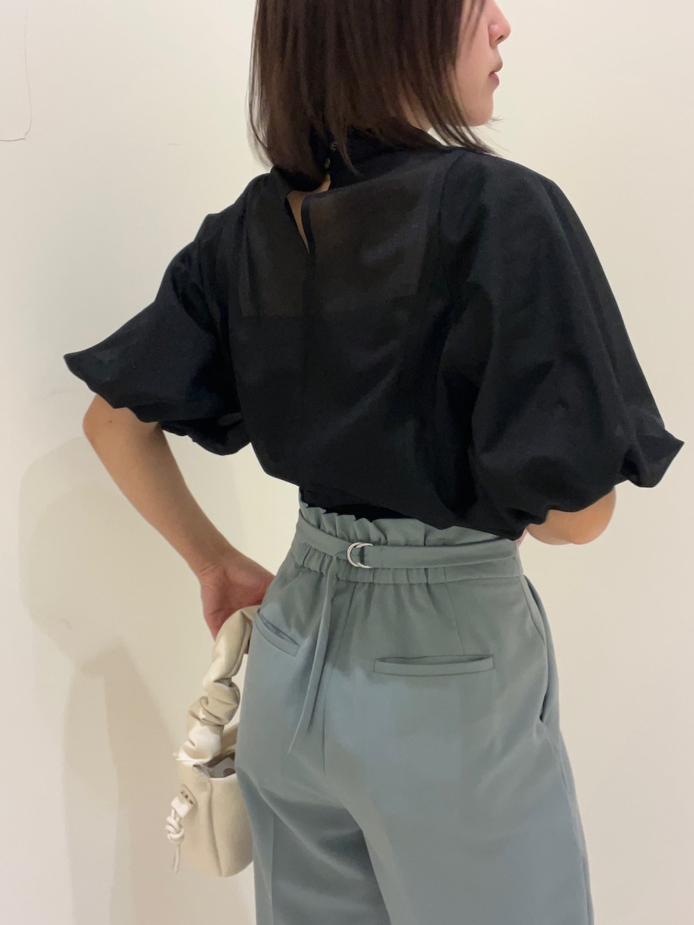 ブラック系のシャツ/ブラウス、ブルー系のその他パンツ、ホワイト系のハンドバッグを着用したレディースの春コーディネートの2枚目の写真