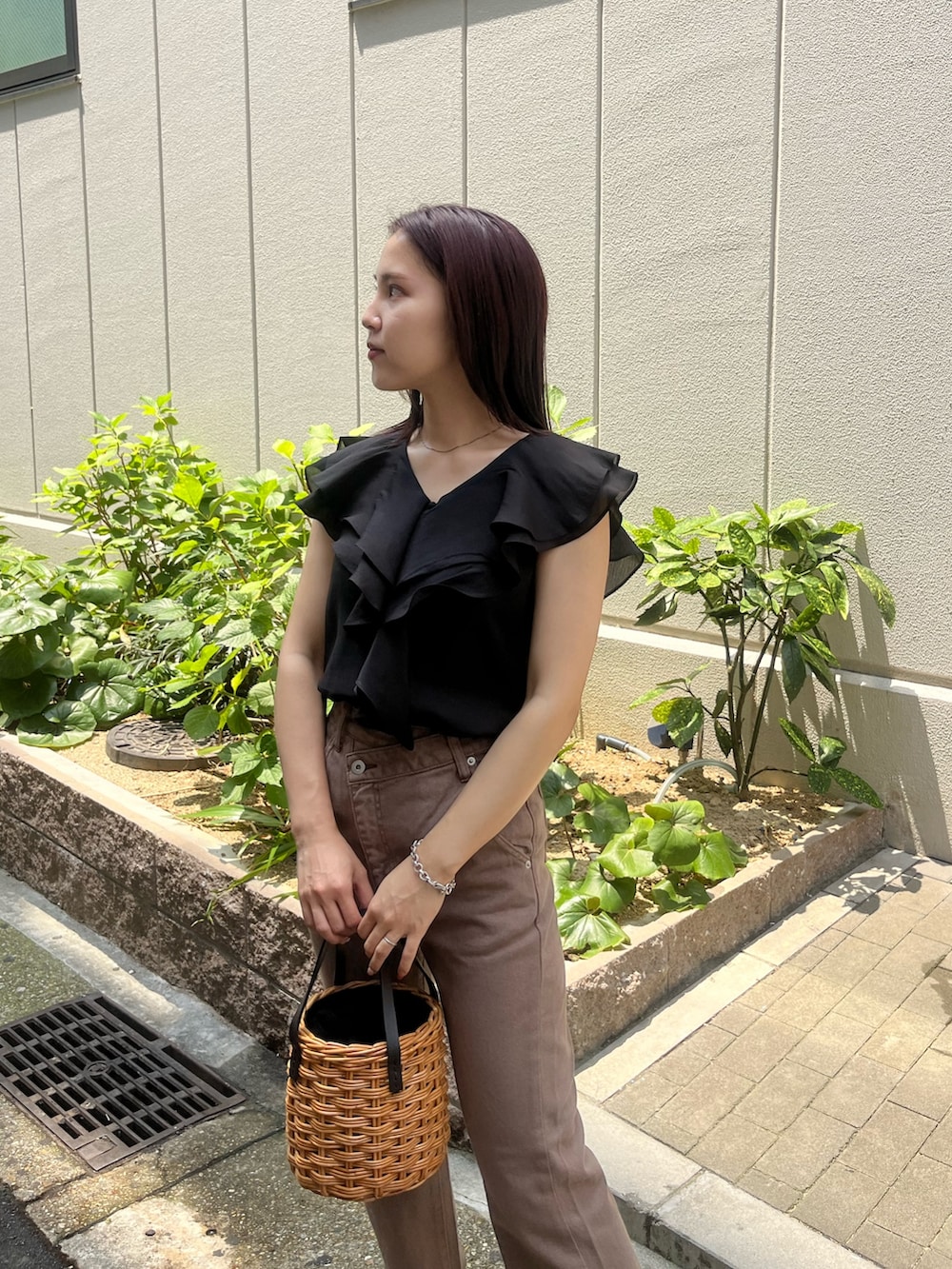 ベージュ系のデニムパンツ、ブラウン系のハンドバッグ、ブラック系のシャツ/ブラウスを着用したレディースの夏コーディネートの4枚目の写真