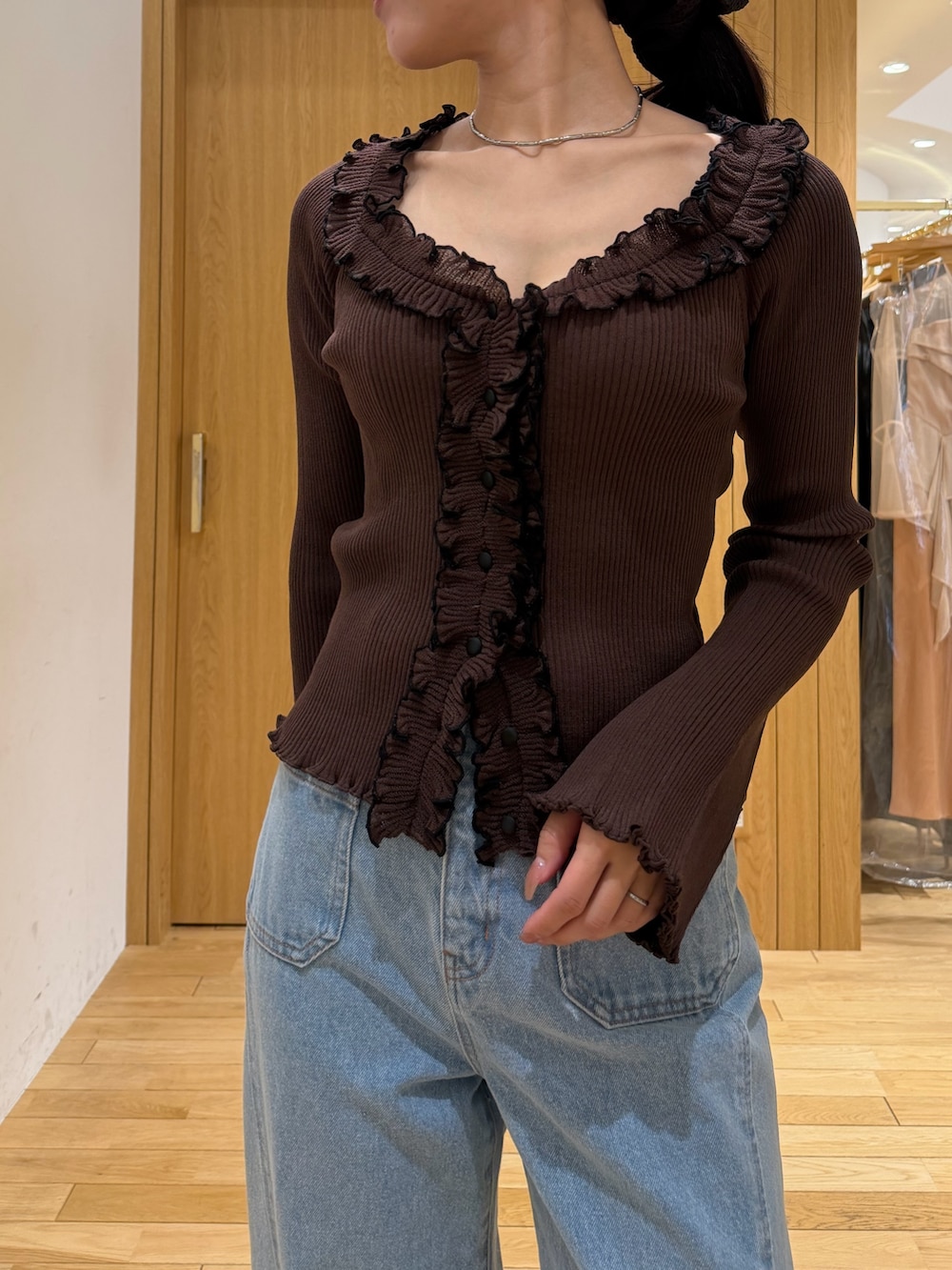 ブラウン系のニット/セーター、ブルー系のデニムパンツ、ブラック系のサンダルを着用したレディースの春コーディネートの4枚目の写真