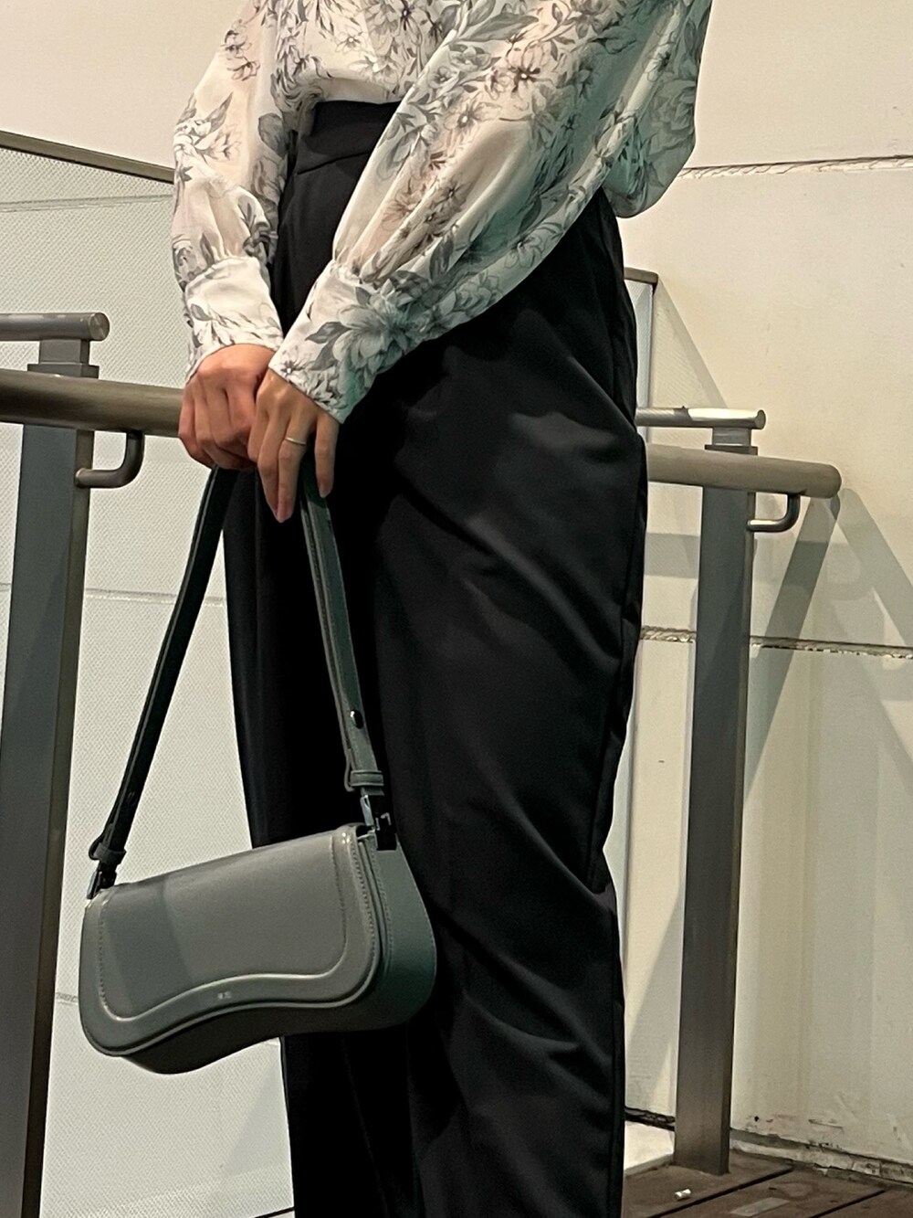 グレー系のシャツ/ブラウス、ブルー系のショルダーバッグ、グレー系のスラックスを着用したレディースの冬コーディネートの6枚目の写真