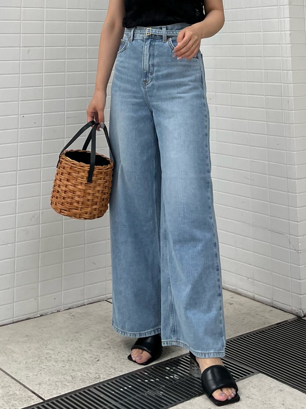 ブラウン系のハンドバッグ、ブラック系のサンダル、ブラック系のシャツ/ブラウスを着用したレディースの夏コーディネートの5枚目の写真