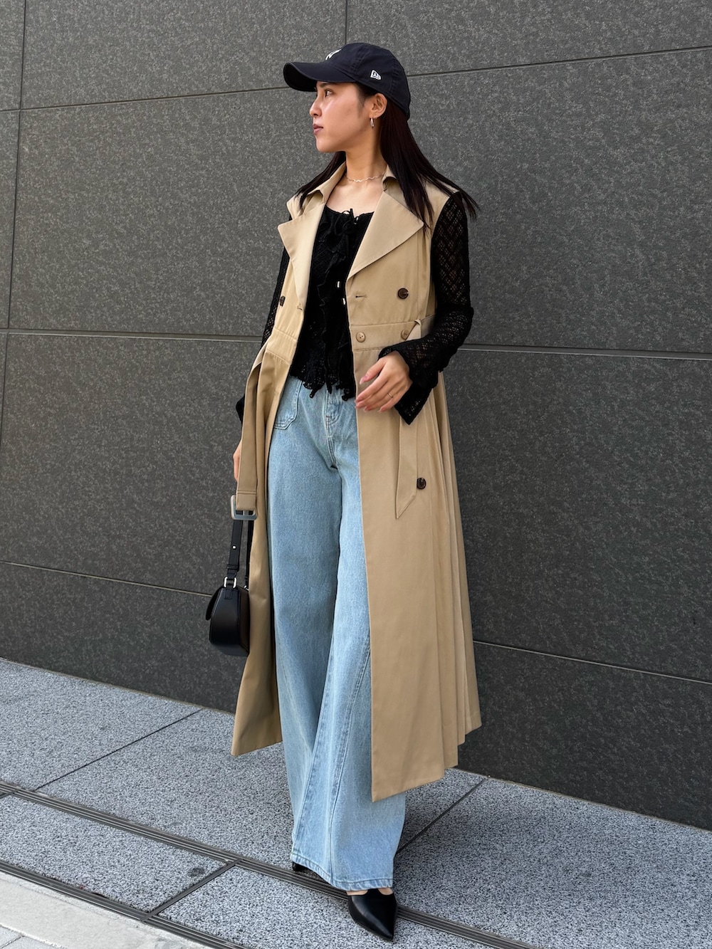 ブラック系のシャツ/ブラウス、ブルー系のデニムパンツ、ベージュ系のトレンチコートを着用したレディースの冬コーディネートの6枚目の写真