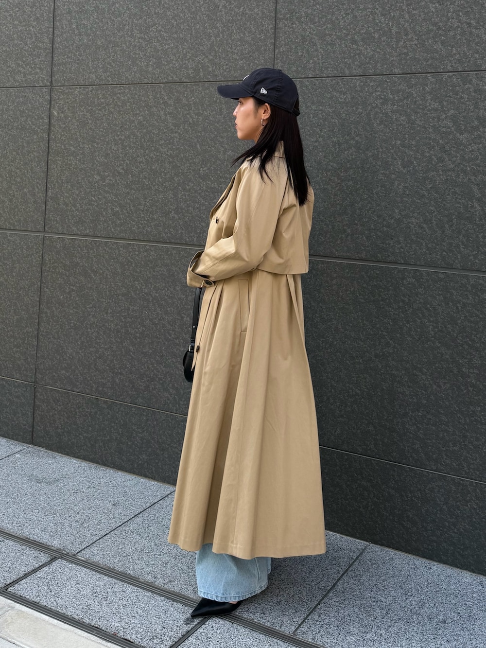 ブラック系のシャツ/ブラウス、ブルー系のデニムパンツ、ベージュ系のトレンチコートを着用したレディースの冬コーディネートの2枚目の写真