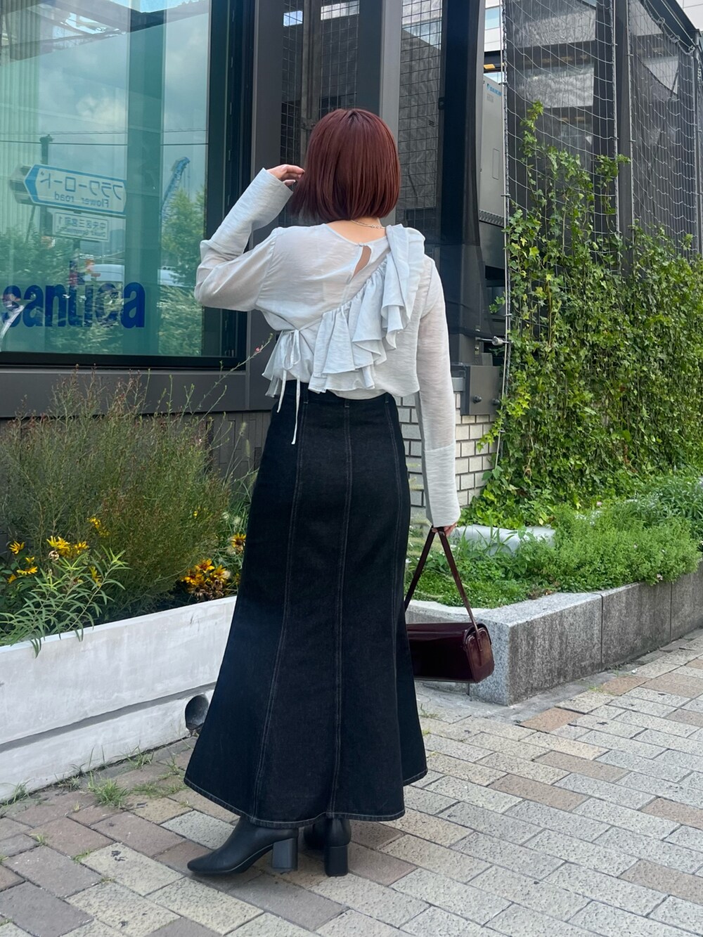 ブラック系のデニムスカート、ブルー系のシャツ/ブラウス、レッド系のショルダーバッグを着用したレディースの秋コーディネートの3枚目の写真