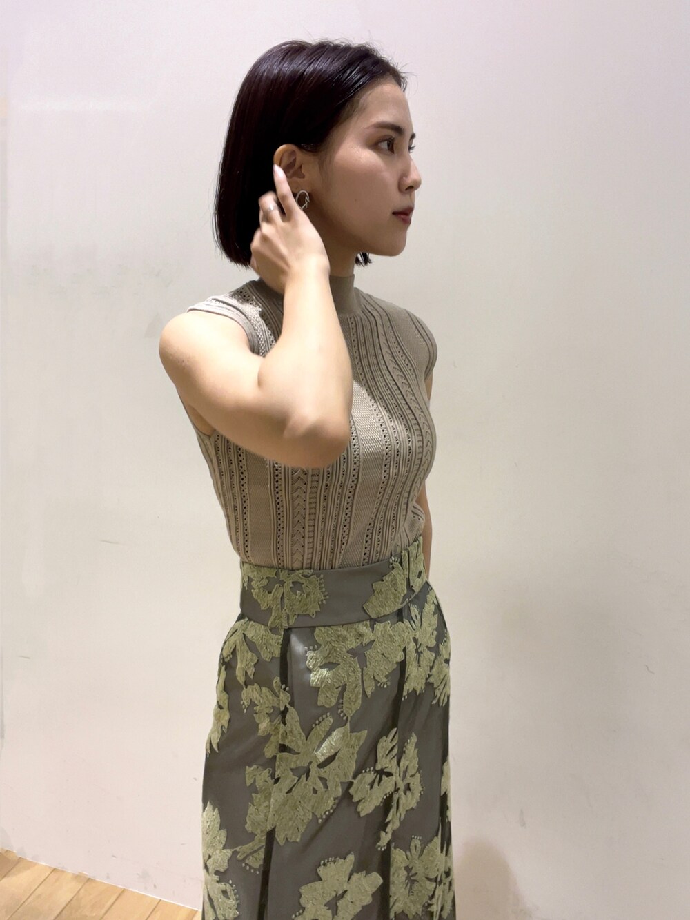 ベージュ系のニット/セーター、グリーン系のスカート、ベージュ系のサンダルを着用したレディースの夏コーディネートの3枚目の写真