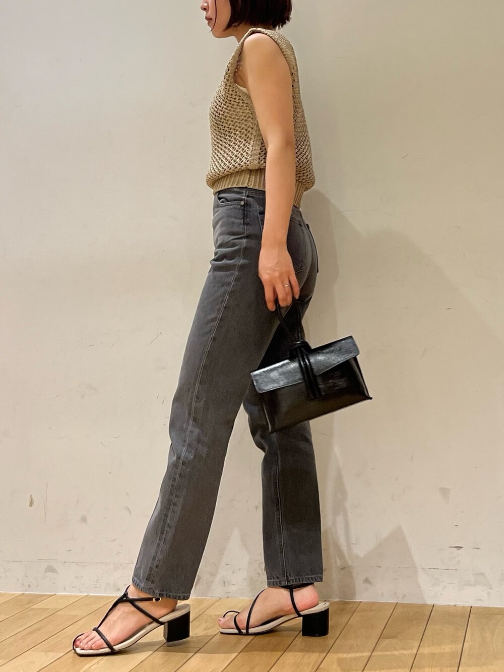 ブラック系のサンダル、ゴールド系のニット/セーター、ブラック系のハンドバッグを着用したレディースの夏コーディネートの3枚目の写真