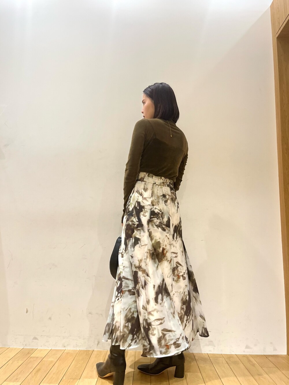 ベージュ系のテーラードジャケット、ブラウン系のTシャツ/カットソー、グリーン系のスカートを着用したレディースの秋コーディネートの6枚目の写真