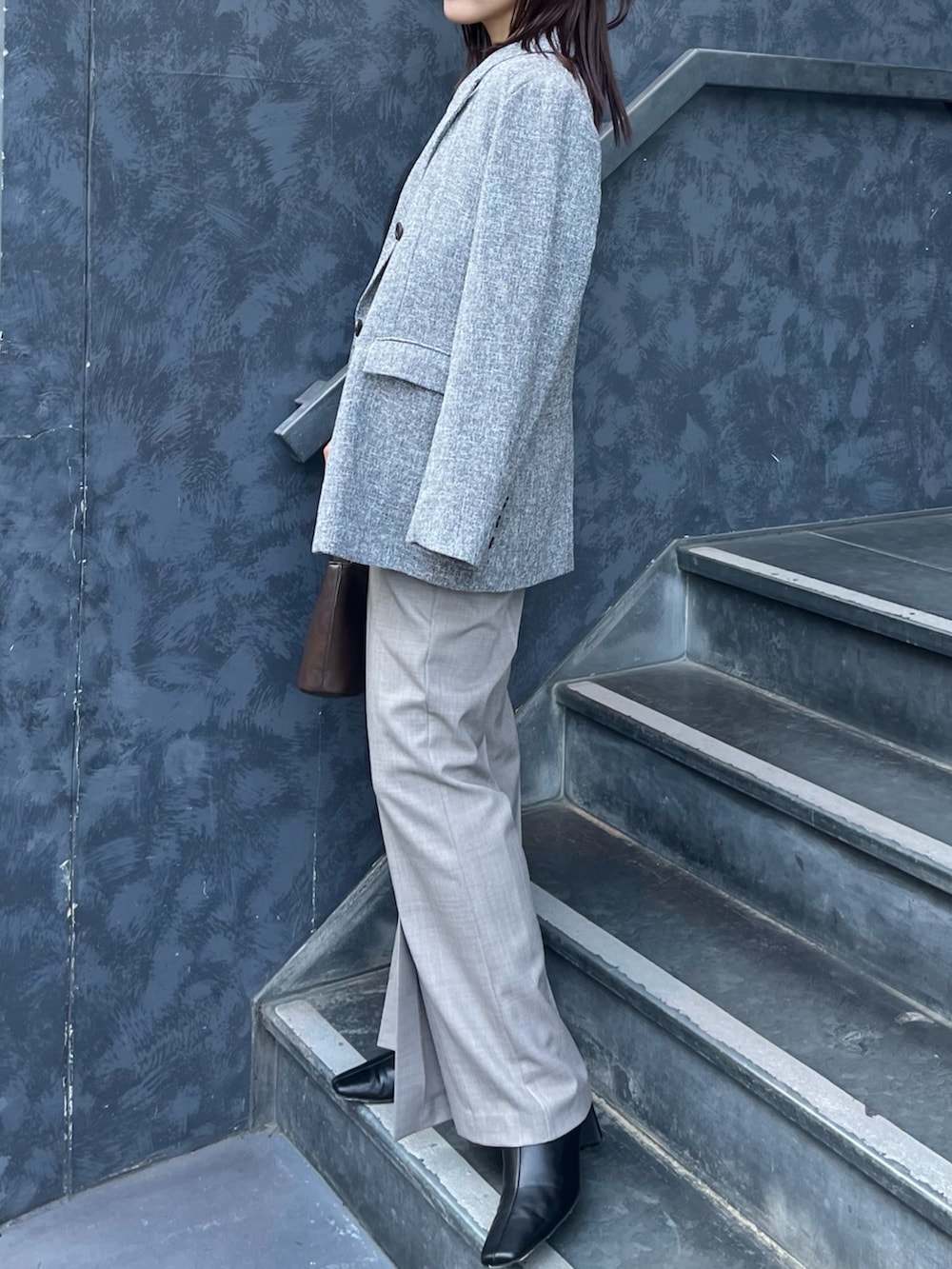 ブラック系のニット/セーター、ブラウン系のハンドバッグ、ブラック系のブーツを着用したレディースの冬コーディネートの2枚目の写真