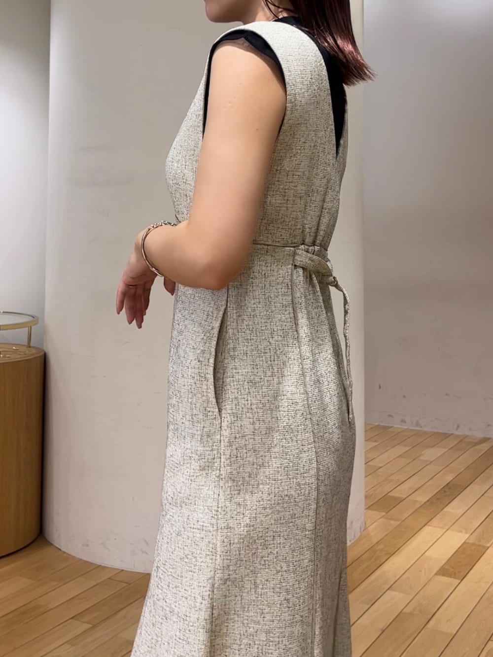 ブラック系のニット/セーター、ホワイト系のジャンパースカート、ブラック系のハンドバッグを着用したレディースの夏コーディネートの7枚目の写真