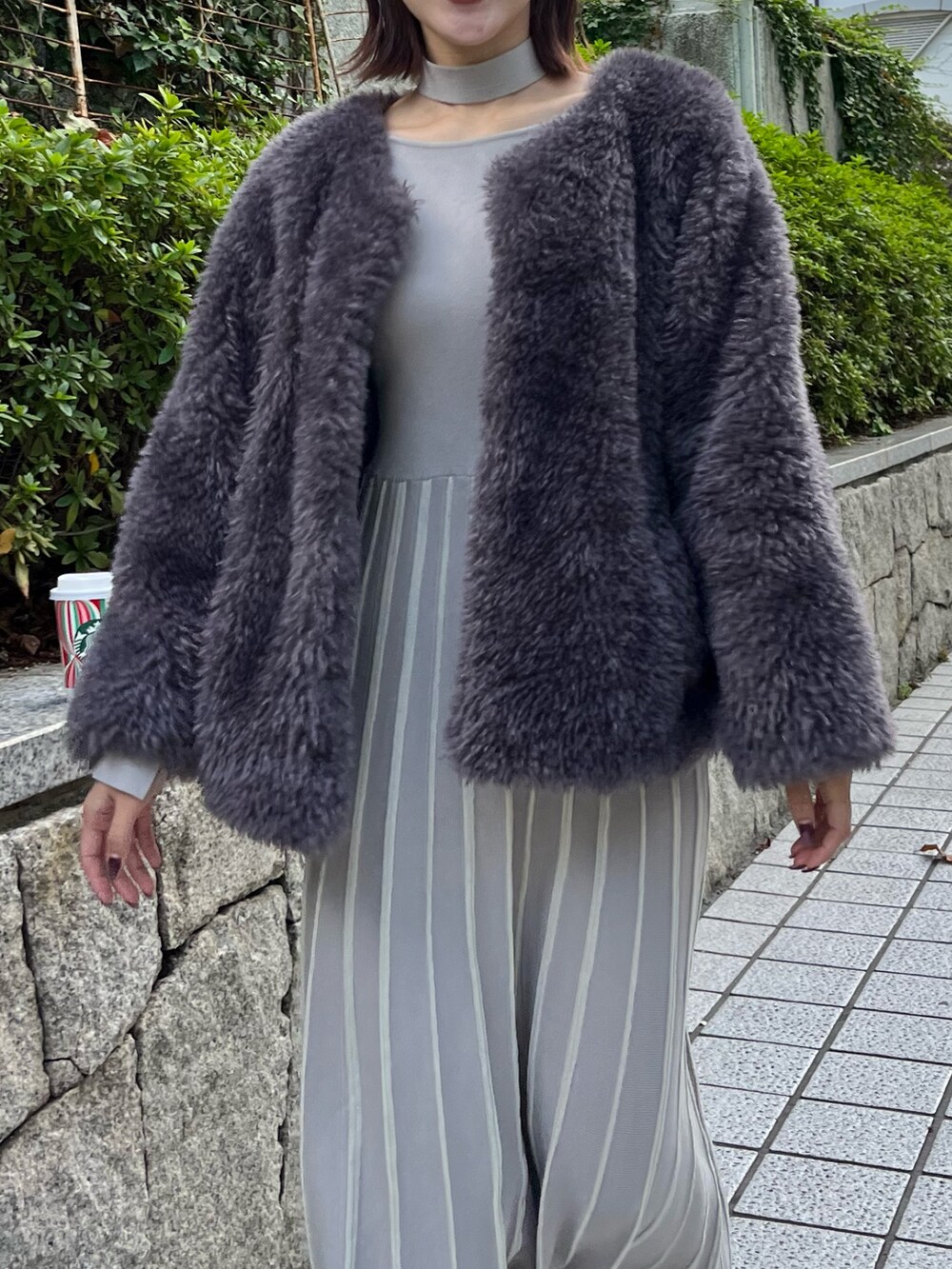 グレー系のブルゾン、グレー系のワンピースを着用したレディースの秋コーディネートの4枚目の写真