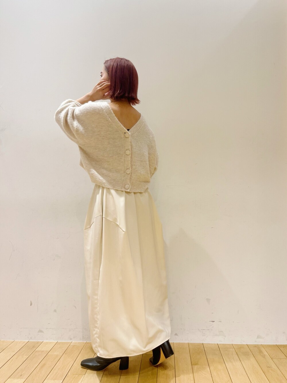 ホワイト系のスカート、ホワイト系のカーディガン/ボレロ、グリーン系のハンドバッグを着用したレディースの秋コーディネートの3枚目の写真