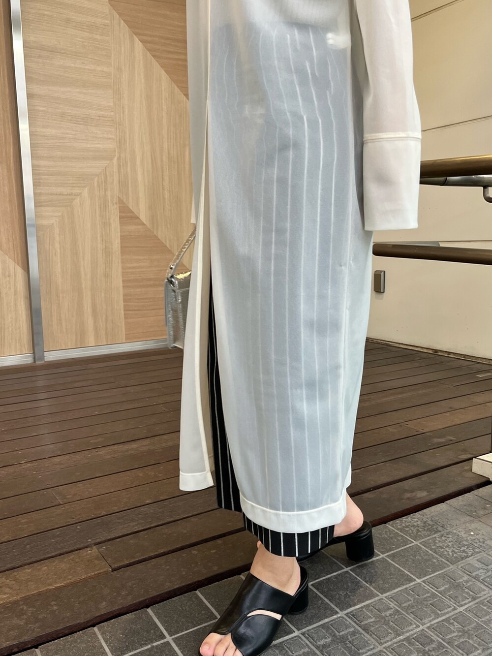 ホワイト系のTシャツ/カットソー、ブラック系のサンダル、ブラック系のスカートを着用したレディースの春コーディネートの4枚目の写真