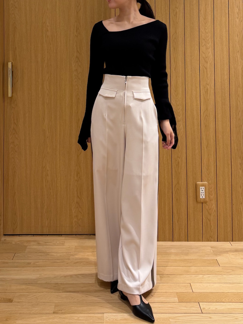 ブラック系のニット/セーター、ブラック系のパンプス、ホワイト系のその他パンツを着用したレディースの冬コーディネートの6枚目の写真