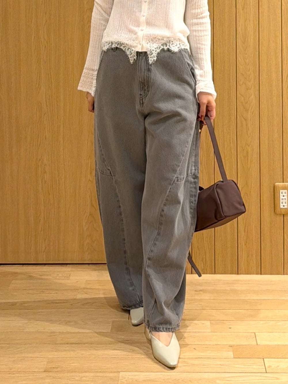 ホワイト系のカーディガン/ボレロ、グレー系のデニムパンツ、ブラウン系のハンドバッグを着用したレディースの秋コーディネートの4枚目の写真