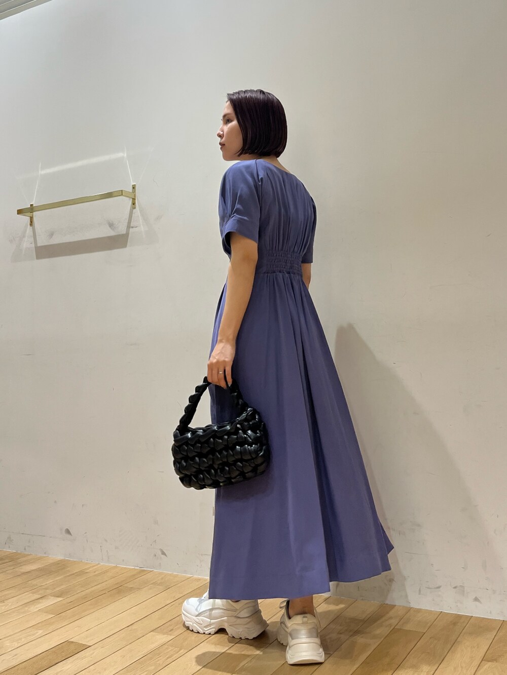 ブルー系のワンピース、ブラック系のハンドバッグ、ホワイト系のスニーカーを着用したレディースの夏コーディネートの3枚目の写真