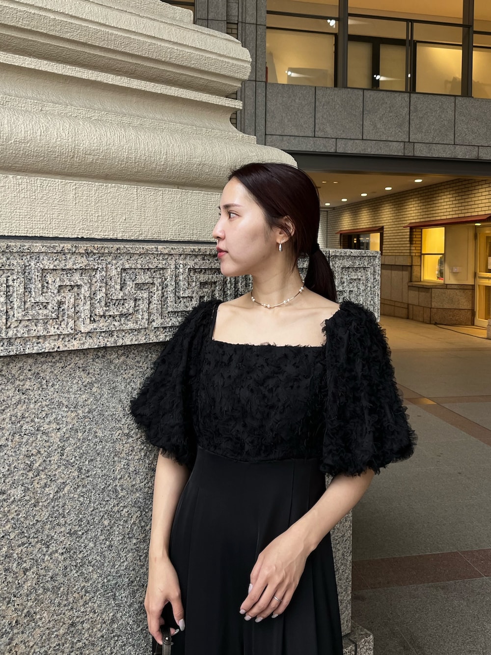 その他のパンプス、ブラック系のパンツドレス、その他のクラッチバッグを着用したレディースの冬コーディネートの5枚目の写真