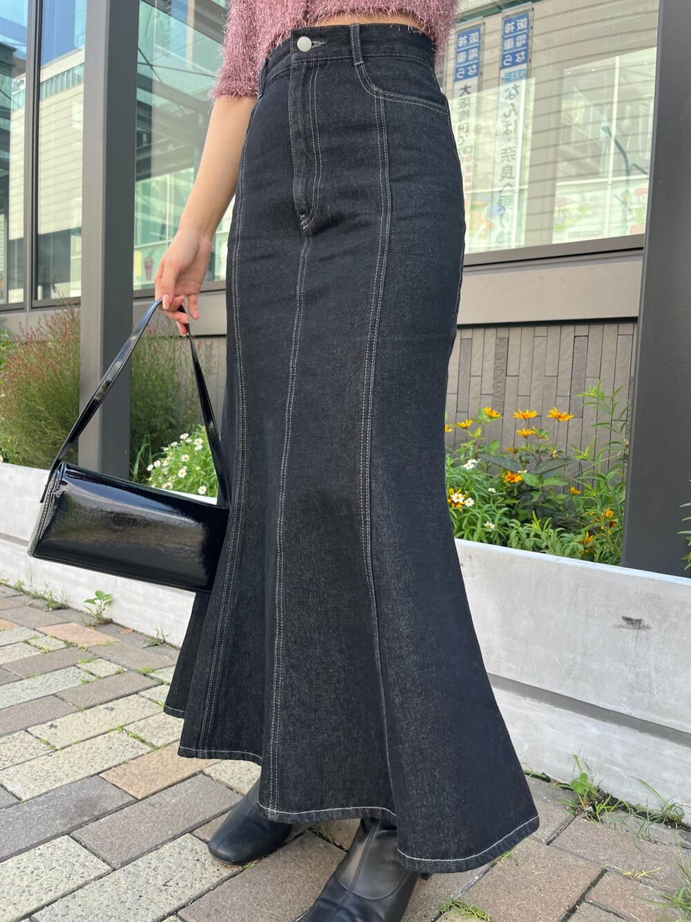 ブラック系のデニムスカート、ピンク系のカーディガン/ボレロ、ブラック系のショルダーバッグを着用したレディースの秋コーディネートの6枚目の写真