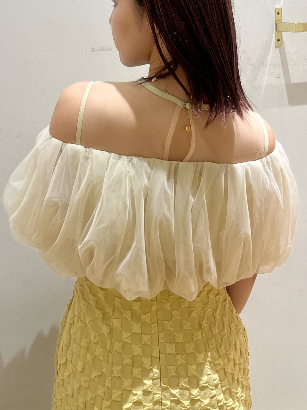 イエロー系のドレス、ブラック系のパンプスを着用したレディースの春コーディネートの5枚目の写真