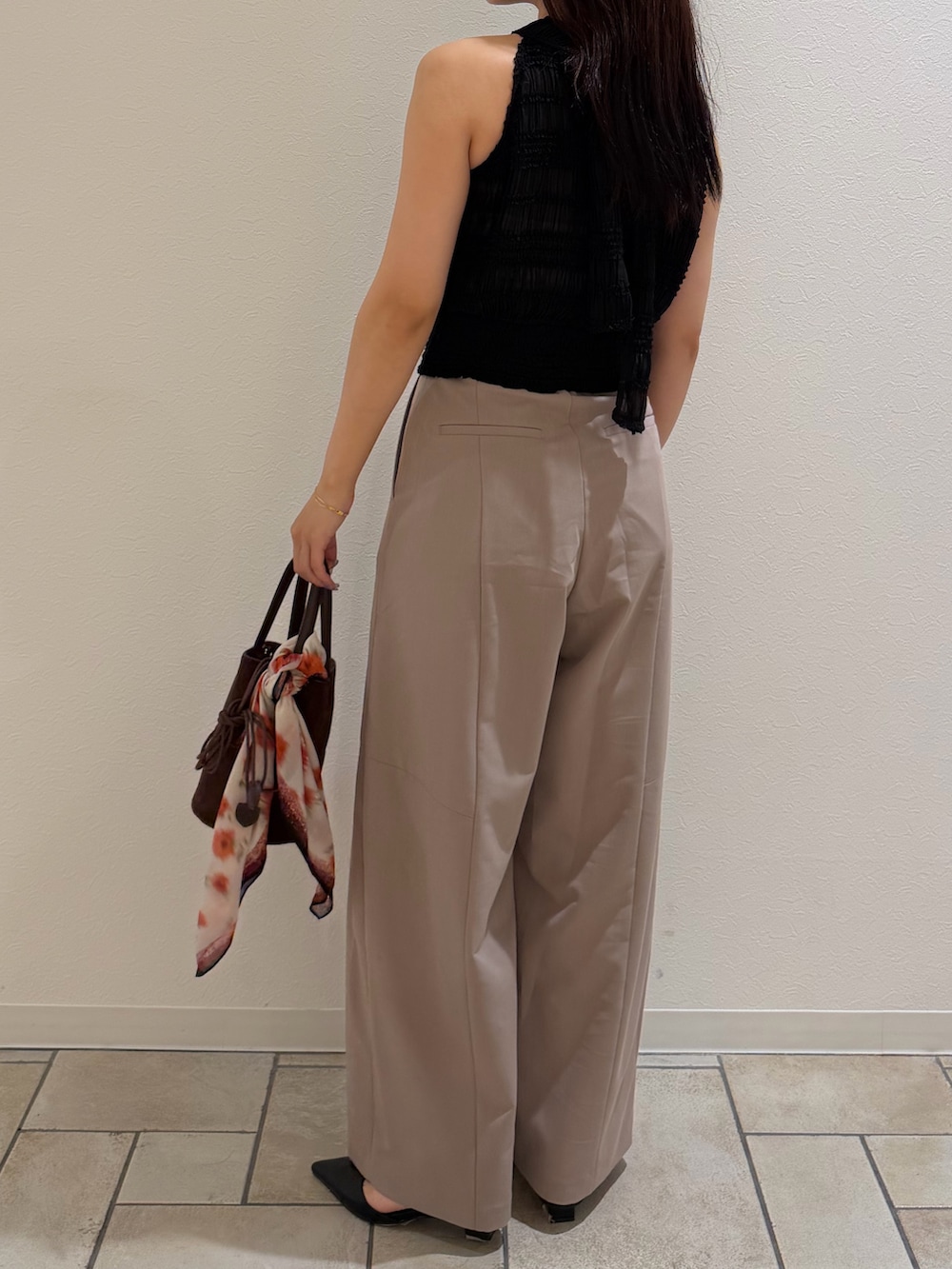 ブラウン系のハンドバッグ、ベージュ系のその他パンツ、ブラック系のシャツ/ブラウスを着用したレディースの夏コーディネートの3枚目の写真