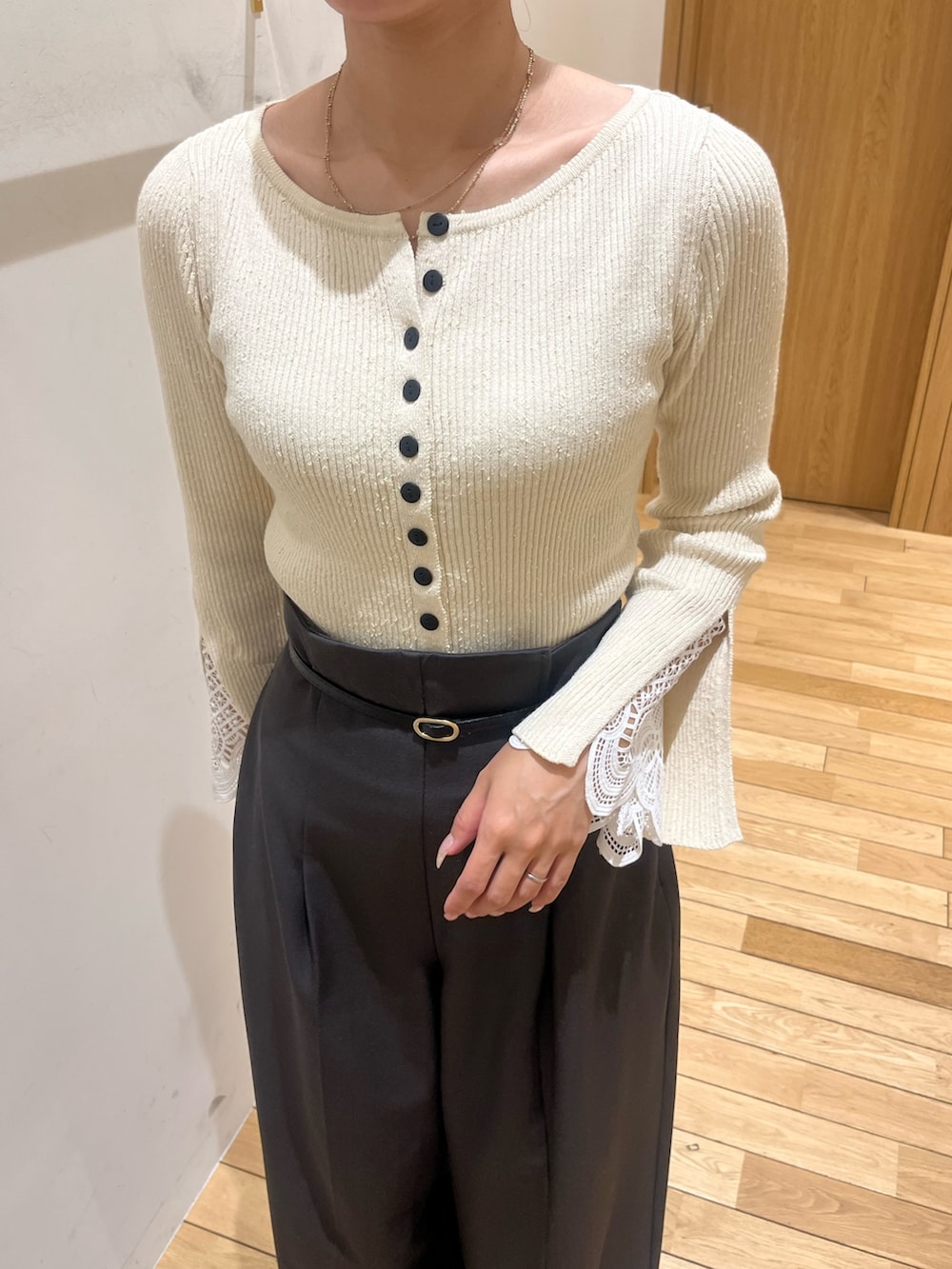 グレー系のその他パンツ、ホワイト系のニット/セーター、ブラウン系のハンドバッグを着用したレディースの冬コーディネートの4枚目の写真