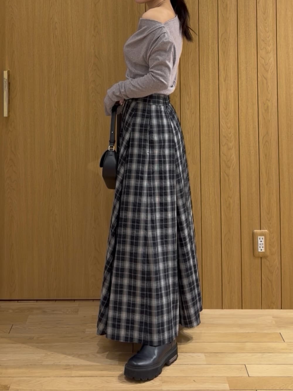 グレー系のTシャツ/カットソー、ブラック系のスカート、ブラック系のハンドバッグを着用したレディースの冬コーディネートの2枚目の写真