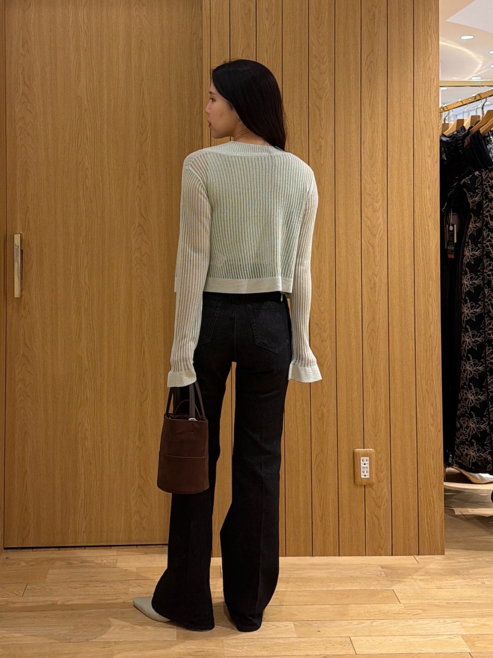 ブラック系のデニムパンツ、ブラウン系のハンドバッグ、グリーン系のパンプスを着用したレディースの夏コーディネートの6枚目の写真