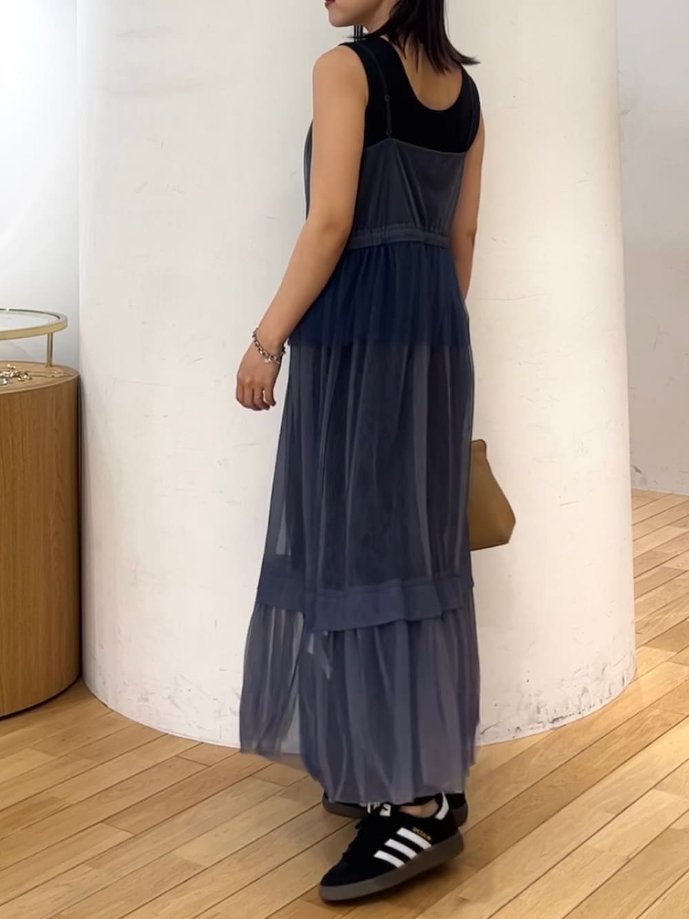 ブラウン系のハンドバッグ、ブラック系のスニーカー、ブルー系のワンピースを着用したレディースの夏コーディネートの3枚目の写真