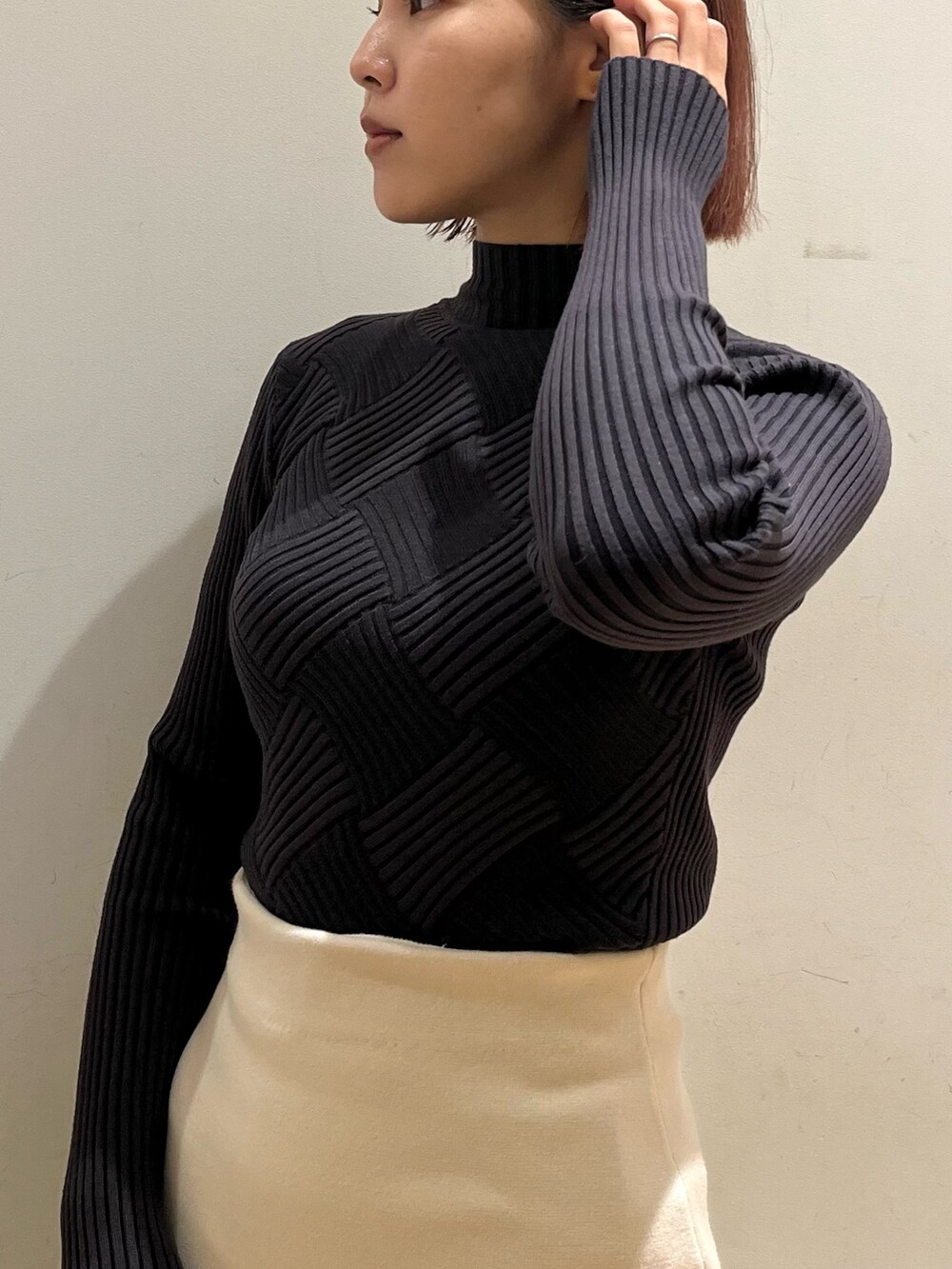 グレー系のニット/セーター、ブラック系のショルダーバッグ、ブラック系のブーツを着用したレディースの冬コーディネートの6枚目の写真