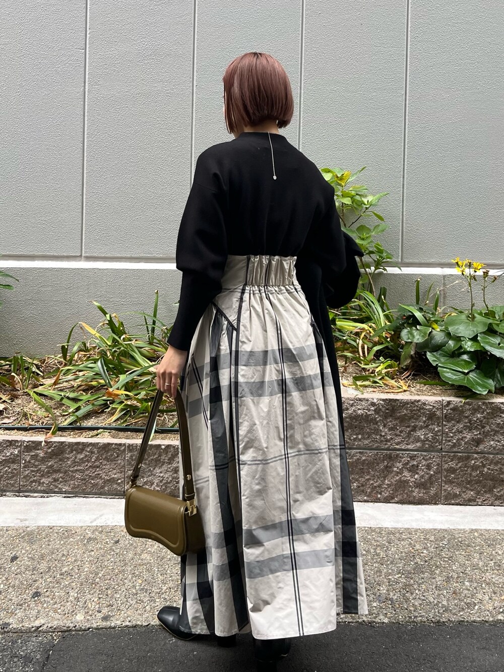 ホワイト系のワンピース、ブラック系のブーツ、ブラウン系のショルダーバッグを着用したレディースの冬コーディネートの3枚目の写真