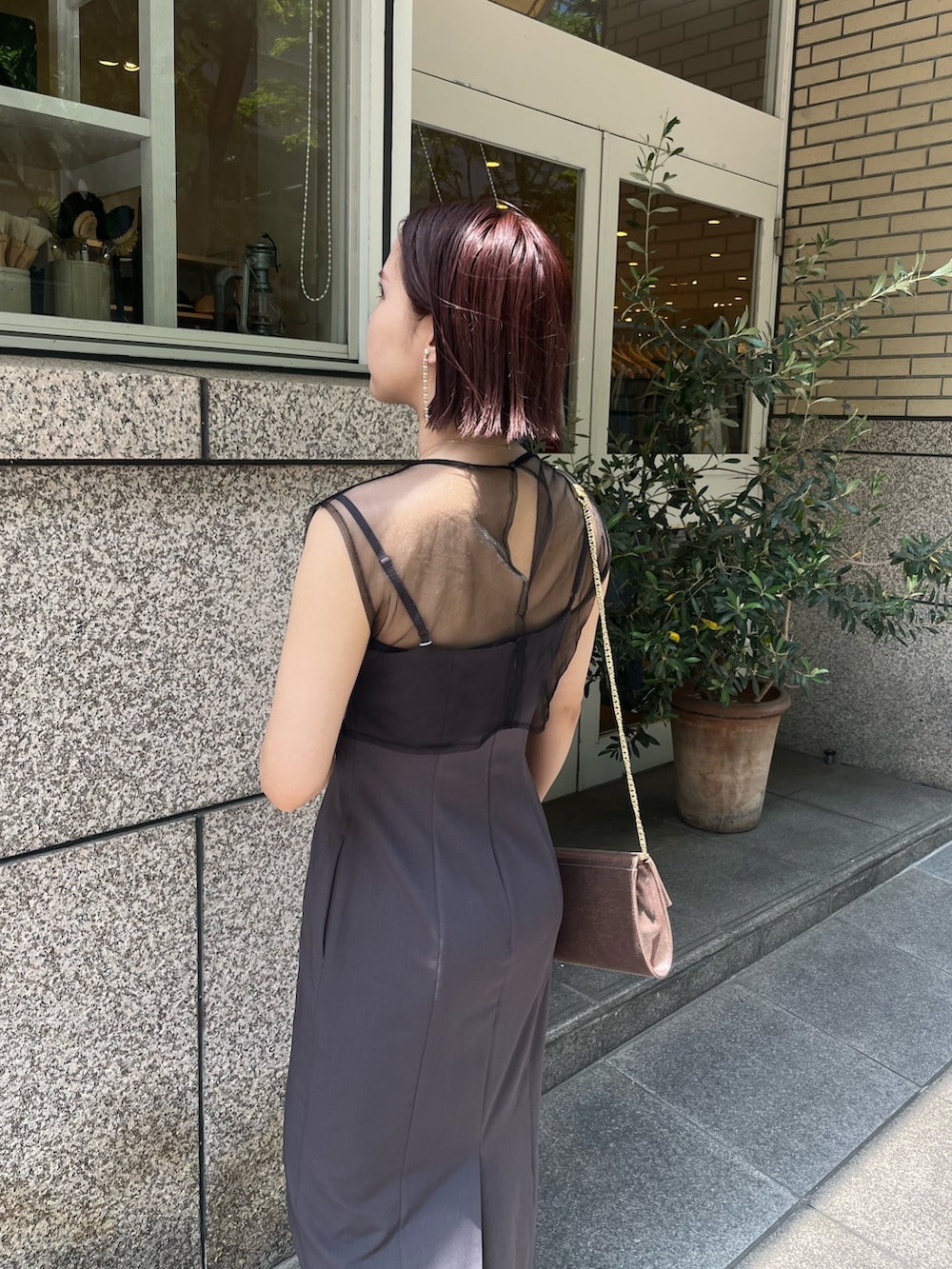 グレー系のドレス、ゴールド系のハンドバッグ、その他のパンプスを着用したレディースの夏コーディネートの5枚目の写真