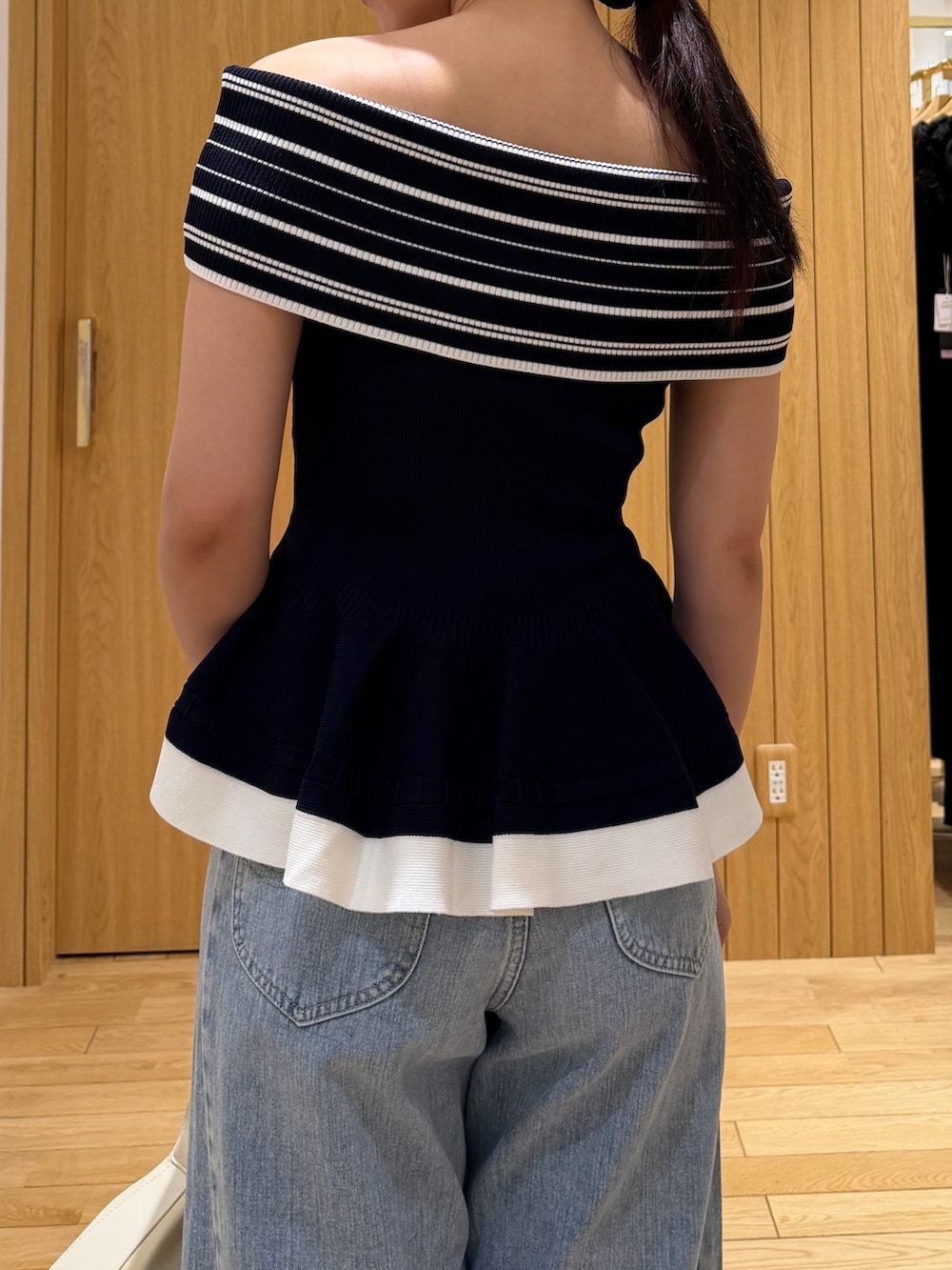 ブルー系のデニムパンツ、ホワイト系のハンドバッグ、ホワイト系のサンダルを着用したレディースの夏コーディネートの6枚目の写真