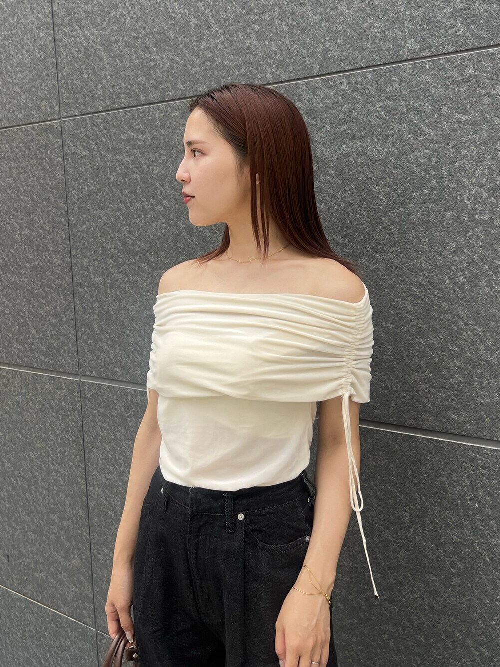 ホワイト系のTシャツ/カットソー、ブラック系のデニムパンツ、ベージュ系のパンプスを着用したレディースの夏コーディネートの6枚目の写真