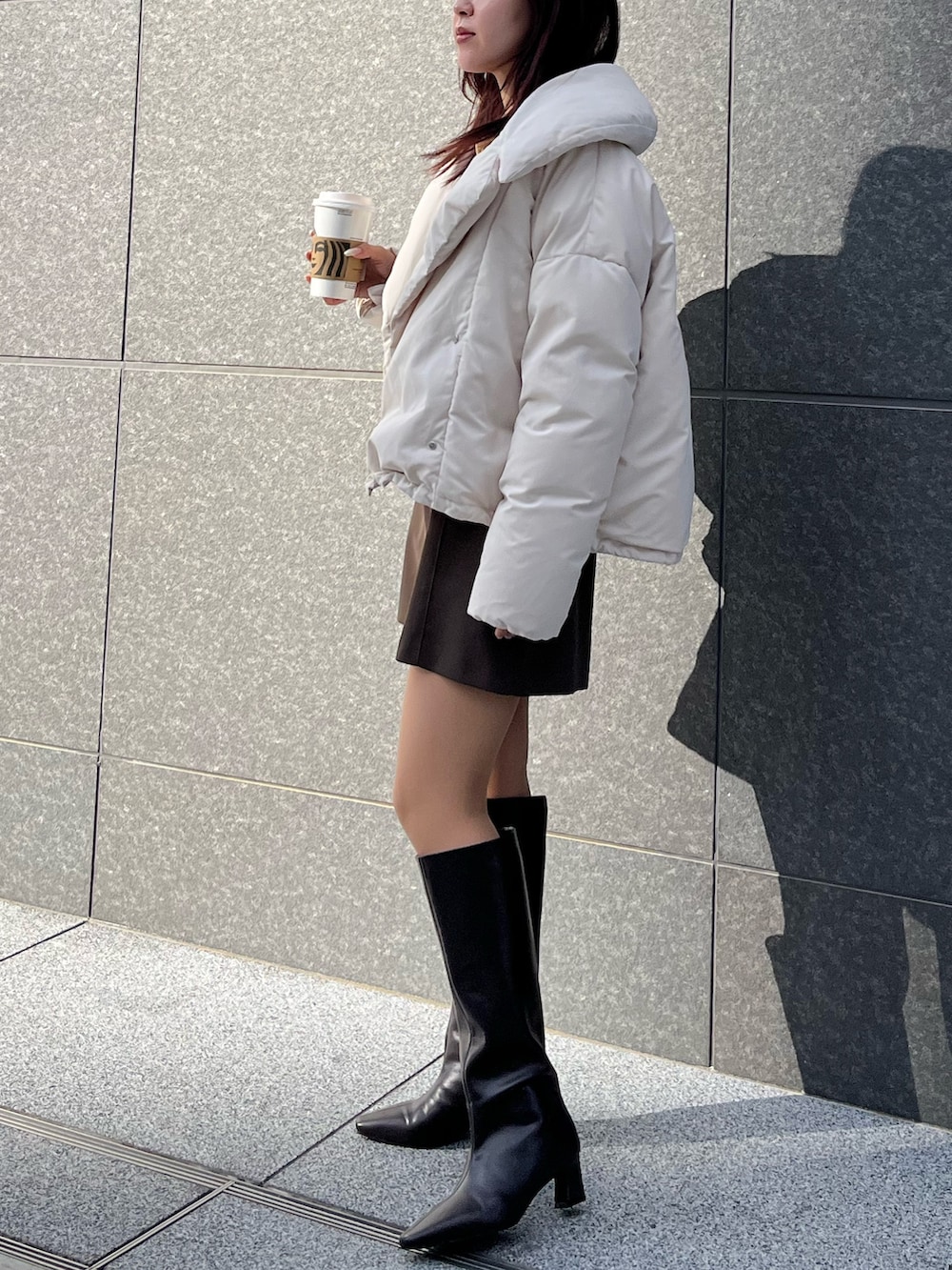 ブラウン系のその他パンツ、ホワイト系のダウンジャケット/コート、イエロー系のカーディガン/ボレロを着用したレディースの冬コーディネートの2枚目の写真