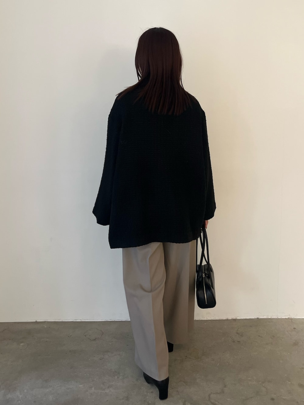 ブラック系のブーツ、ブラック系のニット/セーター、ブラック系のその他アウターを着用したレディースの冬コーディネートの3枚目の写真