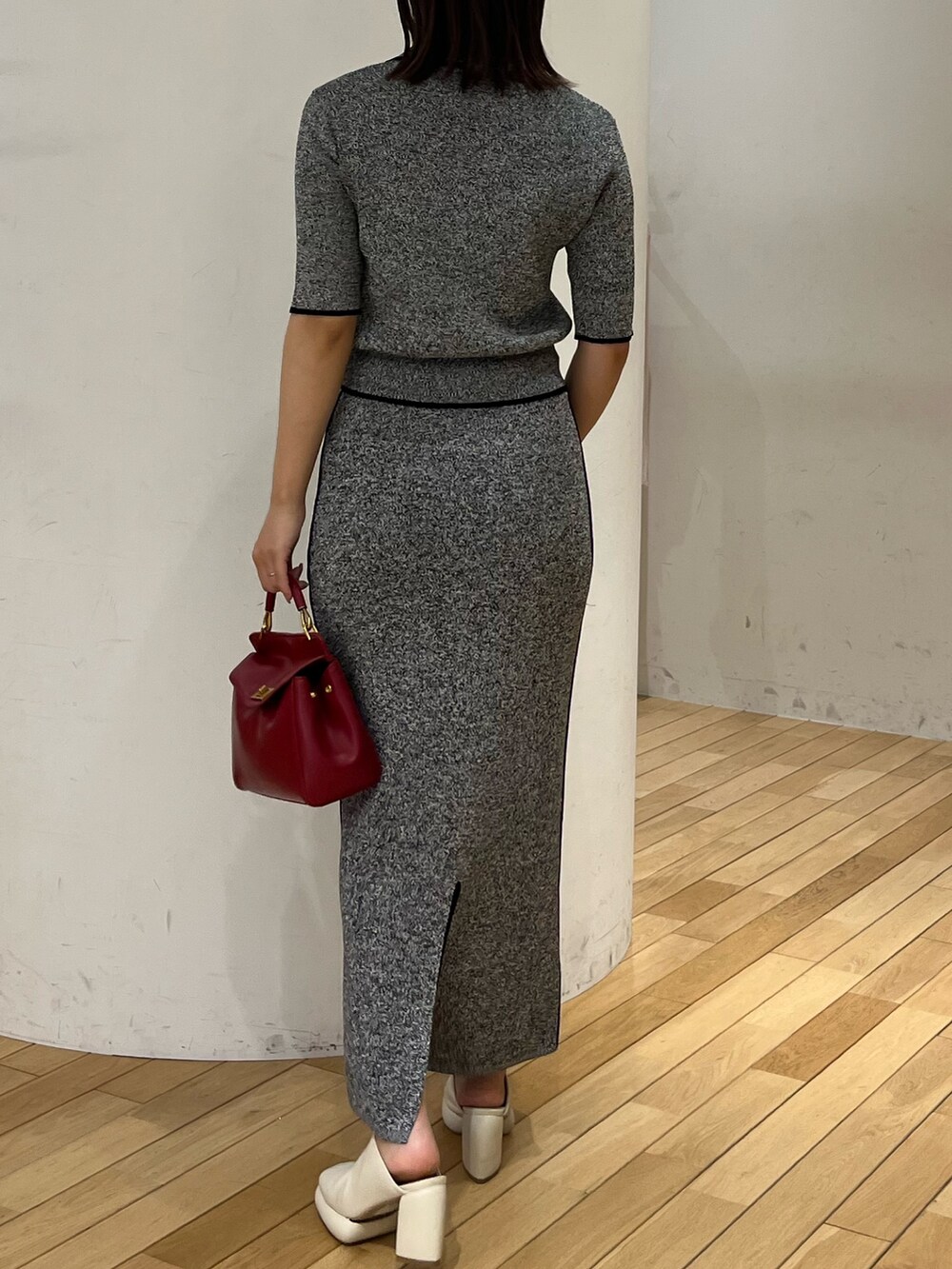 ブラック系のワンピース、レッド系のハンドバッグ、ホワイト系のサンダルを着用したレディースの春コーディネートの3枚目の写真